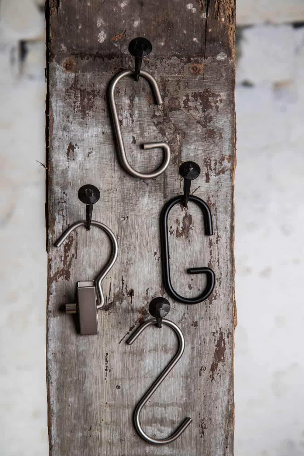 Metall-Kleiderhaken an rustikaler Holzoberfläche, ideal für Shop-Designs.